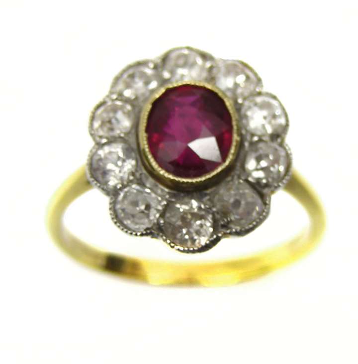 Oval ruby centre and diamond line border cluster ring